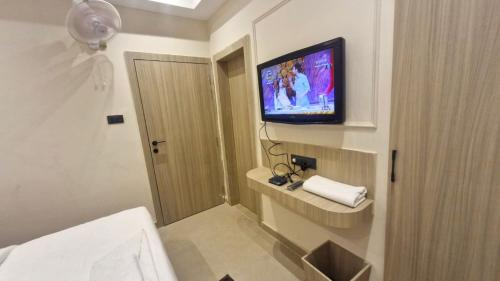 a bathroom with a television on a wall at The City Hotel in Kānpur