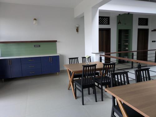 ein Esszimmer mit Holztischen und Stühlen in der Unterkunft Abhimaan in Mysore
