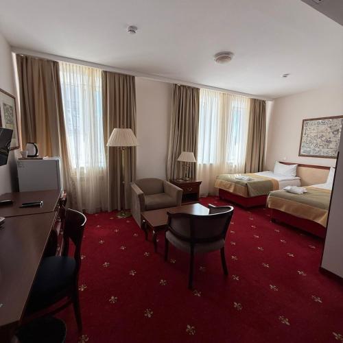 a hotel room with a bed and a desk at Atyrau Dastan Hotel in Atyrau