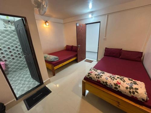 a small room with two beds and a shower at Cozy Inn in Cherrapunji