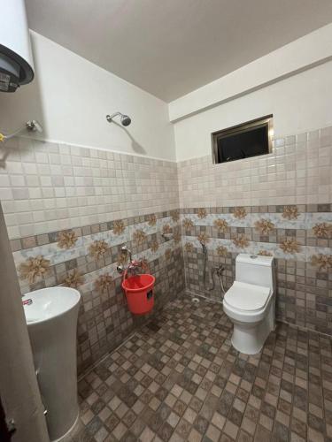 a bathroom with a toilet and a sink at Cozy Inn in Cherrapunji