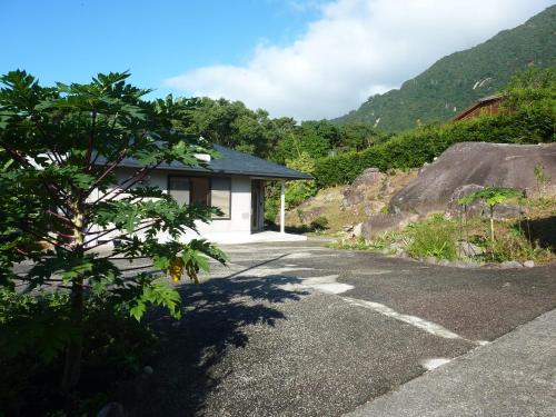 a house in the mountains with a gravel driveway at Sora-mame in Yakushima