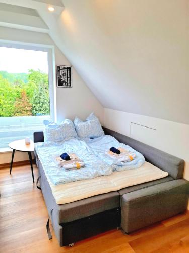 a bed in a room with a large window at Helle Dachgeschosswohnung, neu renoviert & ruhig in Wolfenbüttel