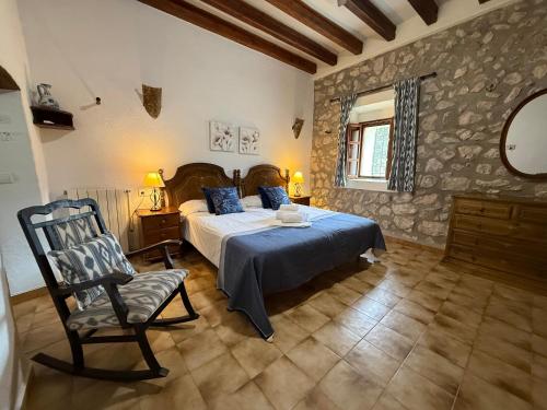 a bedroom with a bed and a chair in it at Agroturismo Can Guillo in Pollença