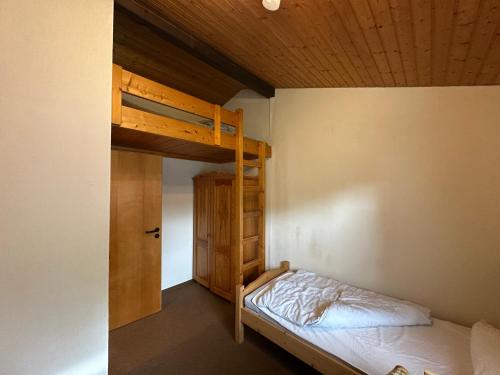 a bedroom with a bunk bed and a wooden ceiling at Ferienhaus Abendgold in Waldbrunn
