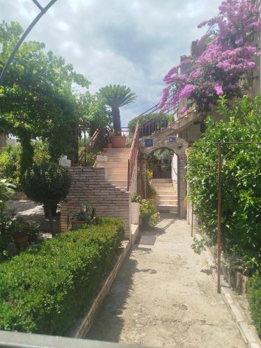 an alley with stairs and trees and flowers at ROOMS LUCE 2 & Supetar in Supetar