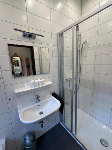 a white bathroom with a sink and a shower at Ferienhaus Abendgold in Waldbrunn