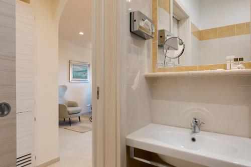 a bathroom with a sink and a mirror at Hotel "La Pensione Svizzera" in Taormina