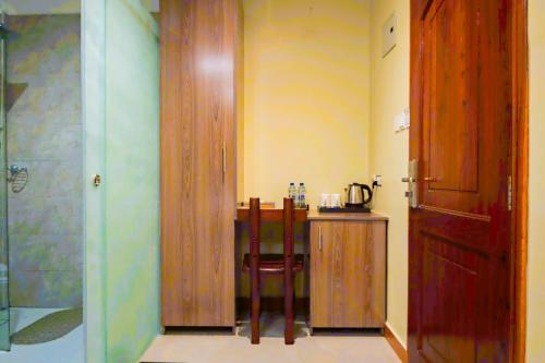 ein Zimmer mit einem Tisch, einem Stuhl und einer Tür in der Unterkunft Green Mountain Hotel in Arusha