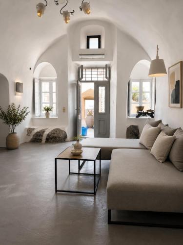 a living room with a couch and a table at Lava On the Cliff in Fira