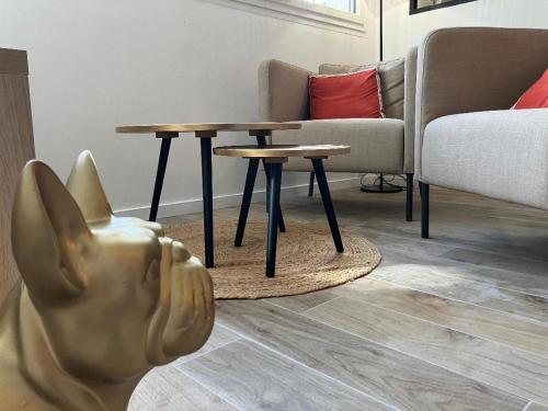 a living room with a couch and a table at Studio Cosy près de la forêt in Saint-Prix