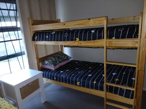 a bedroom with two bunk beds and a table at Healboys Self - catering Accommodation in Bonnievale