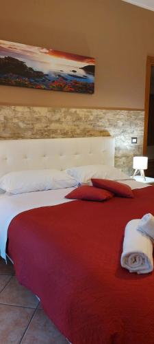 a hotel room with a large bed with red blanket at Casa Vacanze Indaco in Mascali