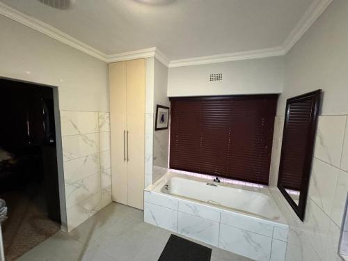 a large bathroom with a tub and a window at Healboys Self - catering Accommodation in Bonnievale