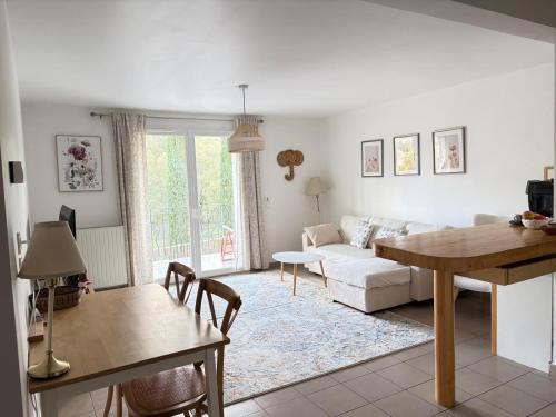 a living room with a white couch and a table at Appartement Belle Vue in Gréoux-les-Bains