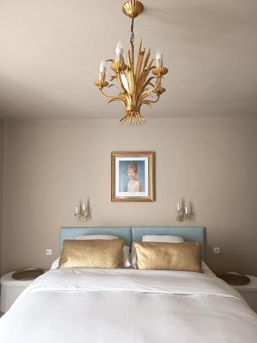 a bedroom with a large bed with a chandelier at Villa Fritzi in Pörtschach am Wörthersee