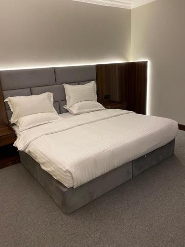 a large bed with white sheets and pillows at شقق اضواء رفا للشقق المخدومة 4 in Al Kharj