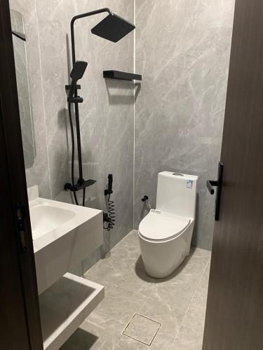 a bathroom with a white toilet and a sink at شقق اضواء رفا للشقق المخدومة 4 in Al Kharj