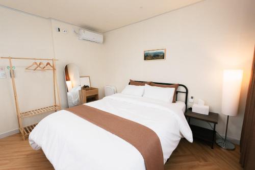 a bedroom with a large bed with white sheets at Stay SUM in Kwarye