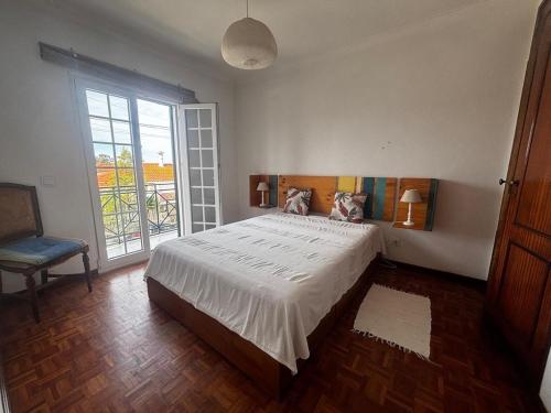 a bedroom with a large bed and a window at Casa do Meco - Private Pool in Sesimbra