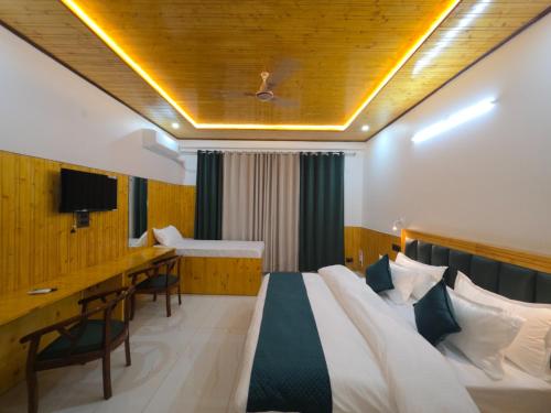 a hotel room with a bed and a desk at Touch wood guest house in Dharmsāla