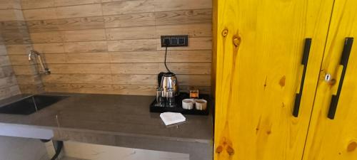 a kitchen with a counter with a coffee maker on it at Touch wood guest house in Dharmsāla