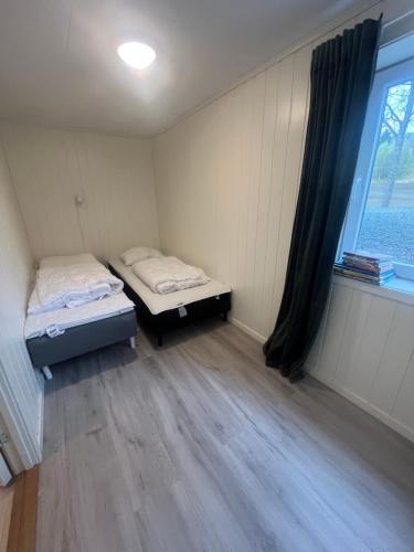 two twin beds in a room with a window at Hammervatnet Ro in Levanger