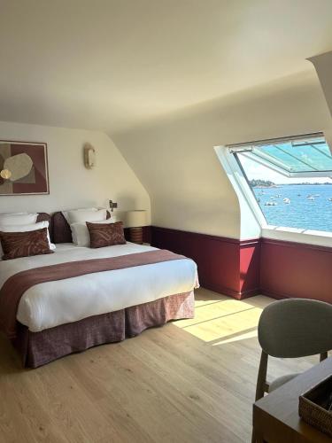 a bedroom with a large bed and a window at Hotel Restaurant Les Venetes in Arradon