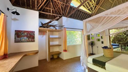 ein Zimmer mit einem Schlafzimmer mit Bett und Fenster in der Unterkunft Watamu Beach Cottages in Watamu
