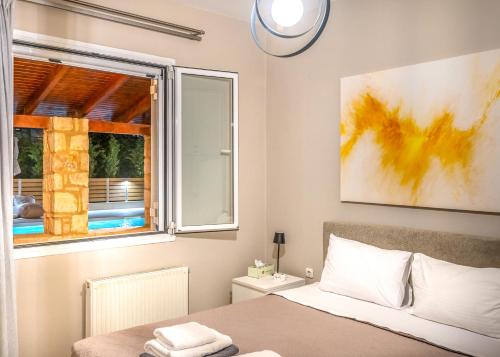 a bedroom with a bed and a window at Casa Di Aspa-Serene Escape with Pool near town in Rethymno