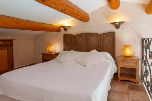 a bedroom with a white bed and two night stands at Chambres d'hôtes et studios de charme - A Mandria in Murato