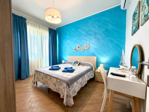 a blue bedroom with a bed and a desk at Castello di Sabbia in Trabia