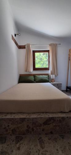 a bedroom with a large bed with a window at Jamm Mare e Monti Tiny house in Orebić