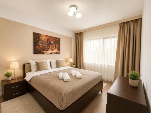 a bedroom with a bed with two towels on it at Vila Panorama - Bunloc in Săcele
