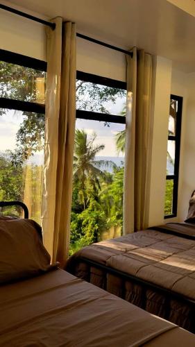 a bedroom with two beds and a large window at Buxton Gan Resort Hotel in San Andres