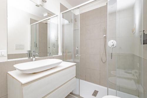 a white bathroom with a sink and a shower at CityLife in Bergamo