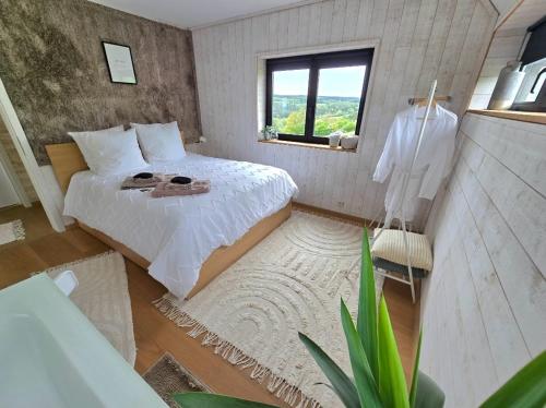 a bedroom with a white bed and a window at Nature Circuit Francorchamps in Stavelot
