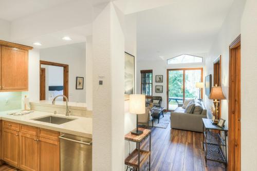 a kitchen with a sink and a living room at Lodge at Brookside, A Vail Resorts Property in Avon