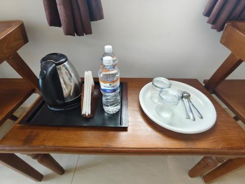 a table with a plate and a bottle of water at RVS Chalet in Pondicherry