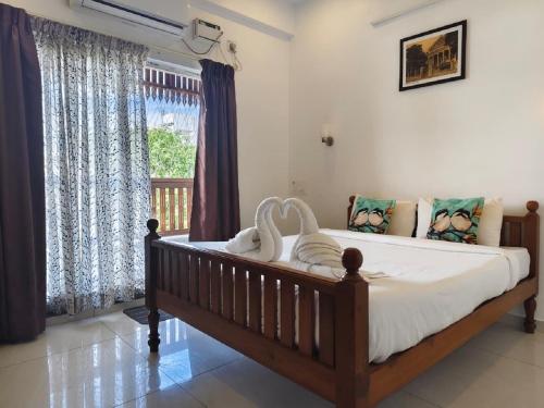 a bedroom with a large bed and a window at RVS Chalet in Pondicherry