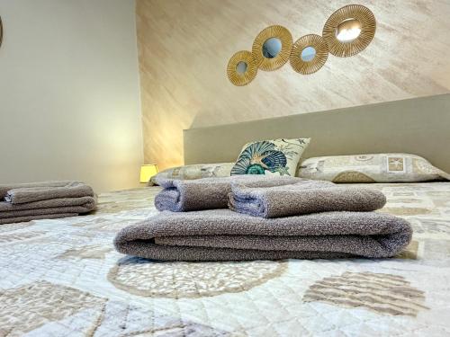 a bedroom with a pile of towels on a bed at Castello di Sabbia in Trabia
