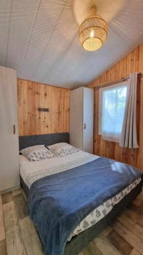 a bedroom with a large bed with a blue blanket at Gîtes du Bois de Bontemps in Sarlat-la-Canéda