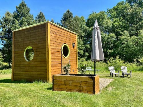 a small shed with an umbrella and a table and chairs at Domaine de la Grangée in La Chapelle-Blanche-Saint-Martin