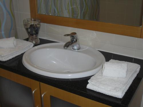 uma pia branca com toalhas sobre um balcão em um banheiro em Apartment Belleview em Lagos