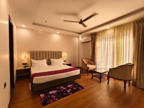 a bedroom with a bed and a chair and a window at Jakk Residency, ILBS Hospital in New Delhi
