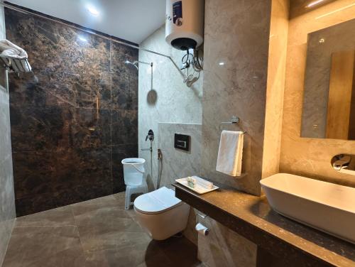 a bathroom with a sink and a toilet and a shower at Jakk Residency, ILBS Hospital in New Delhi
