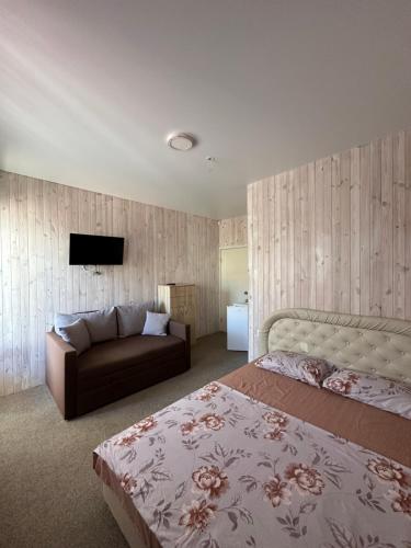 a bedroom with a bed and a couch at Villa Bossa in Zatoka