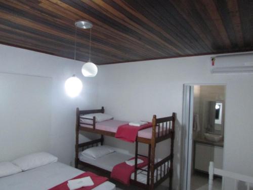 a room with two bunk beds and a ceiling at Pousada Sonho Meu in Penha