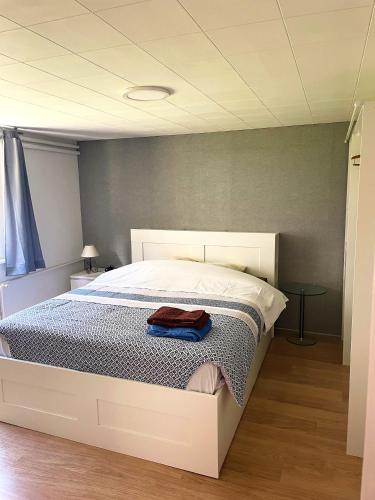 a bedroom with a white bed with a towel on it at Gîte 'A deux pas du ciné' in Maîche