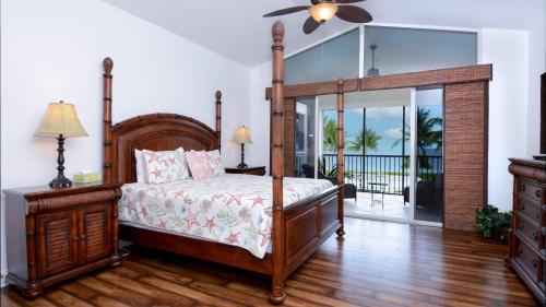 a bedroom with a canopy bed and a balcony at 409 Mariners Club in Key Largo